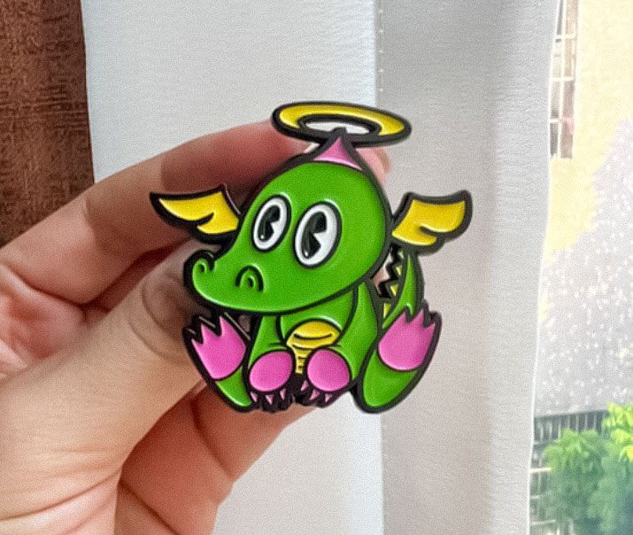 Enamel pin of a winged chibi gator
