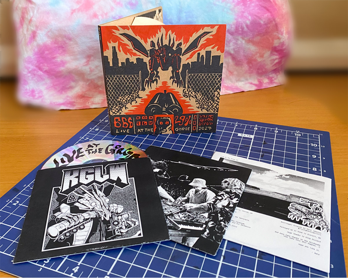 A CD case with black and orange print on kraft paper depicting a Doom game-like interface with robot dragon in a destroyed city with a shotgun pointed at it. Around it are a set of black and white CD sleeves. From left to right, a metal robot with the text KGLW written above, a photo of a group of people around a synth table, and the last sleeve is a landscape photo with text below.